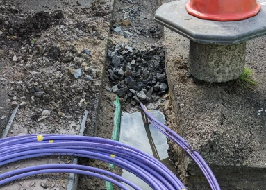 Fibre optic cable coming out of a trench curled up waiting to be installed for the UK gigabit broadband rollout